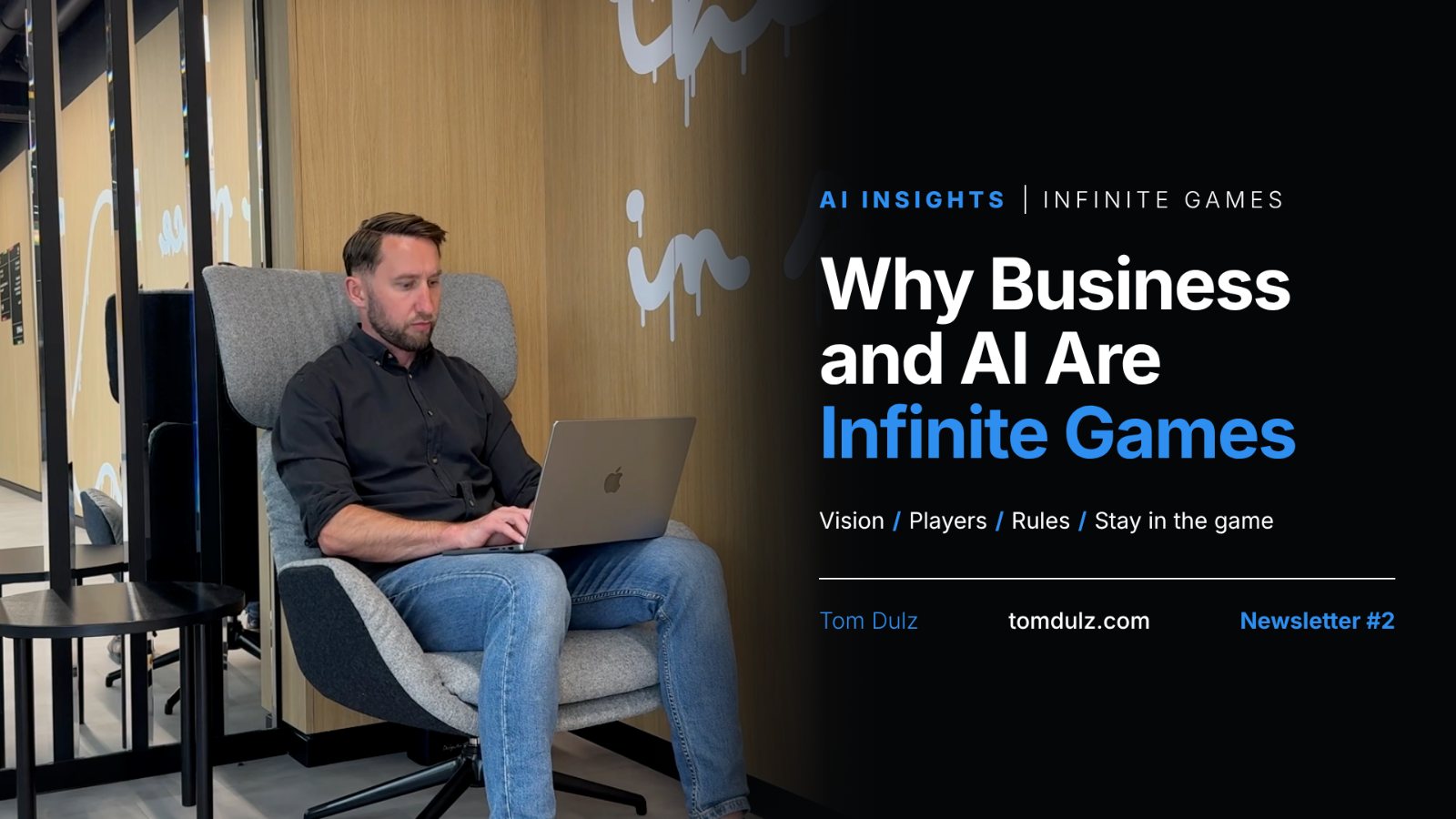 Tom Dulz working on a laptop in a grey armchair. Title: Why Business and AI Are Infinite Games. Vision, Players, Rules, Stay in the game. Beyond Tactics, Newsletter #2.